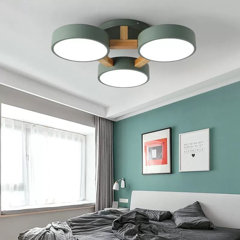 Green Minori three-disc ceiling light in a bedroom with a green wall.