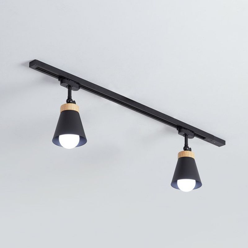 Black Haney ceiling rail with two cone shades, short stems, light wood-tone collars and visible bulbs against pale background