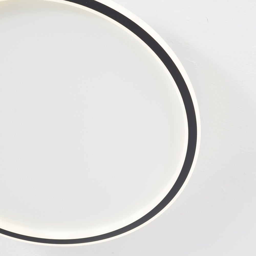 Close view from below of the curved Black band and White illuminated diffuser around the open center