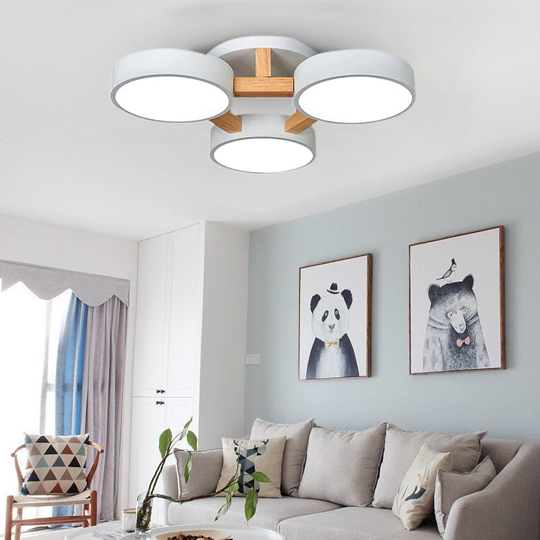 White Minori three-disc ceiling light in a room with framed animal artwork.