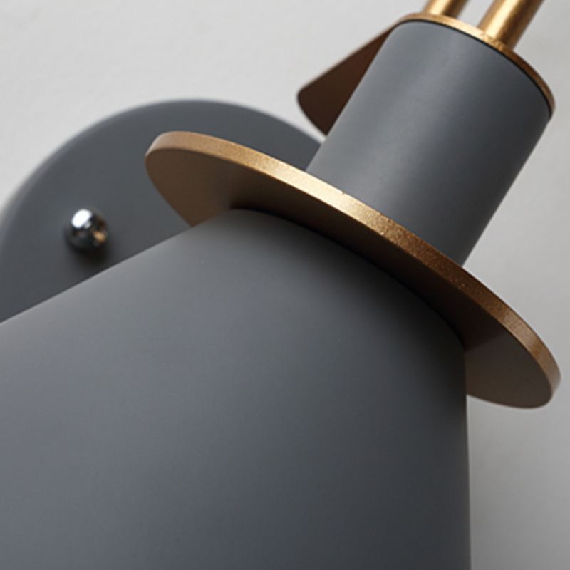 Grey shade shoulder and upper cylinder with gold-coloured rim beside the round wall plate