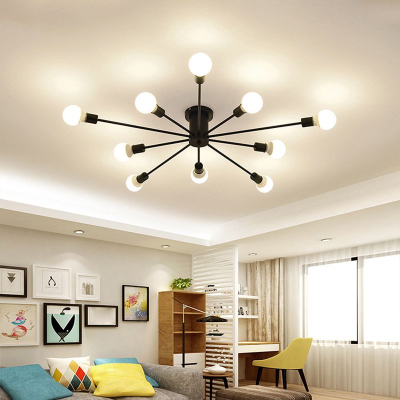 Black ten-light radial fixture in a living room with sofa, desk, yellow chair, wall art and bright window