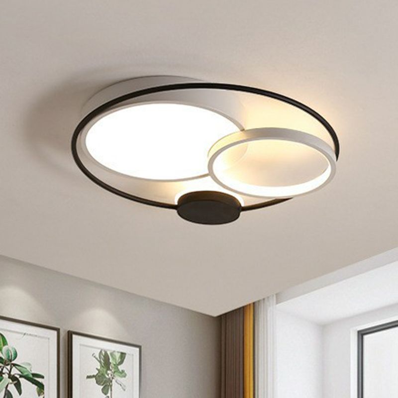 Black-and-white Lacey ceiling light with unequal circular diffusers above a bright living space.