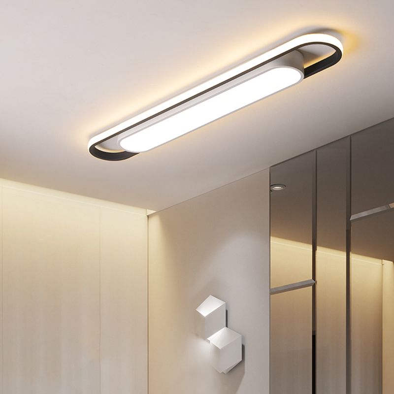 Lit linear ceiling fixture above a hallway wardrobe and white geometric wall ornaments