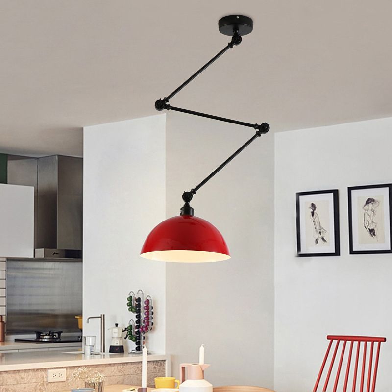 Red dome pendant with a black jointed arm in a kitchen and dining room with a red chair