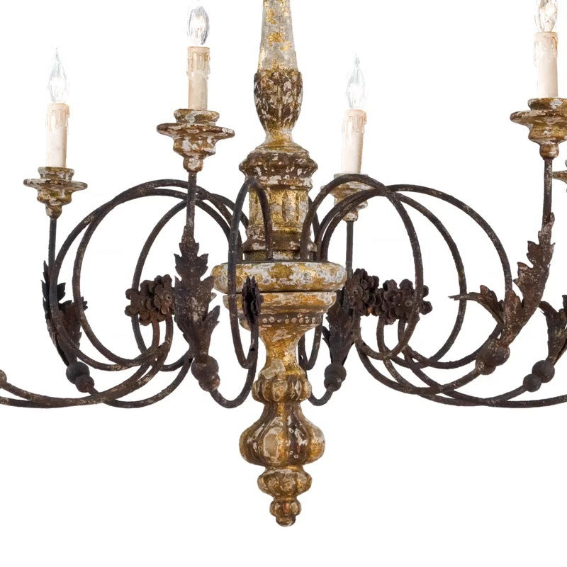 Detail of distressed decorative surfaces and scrolling chandelier arms