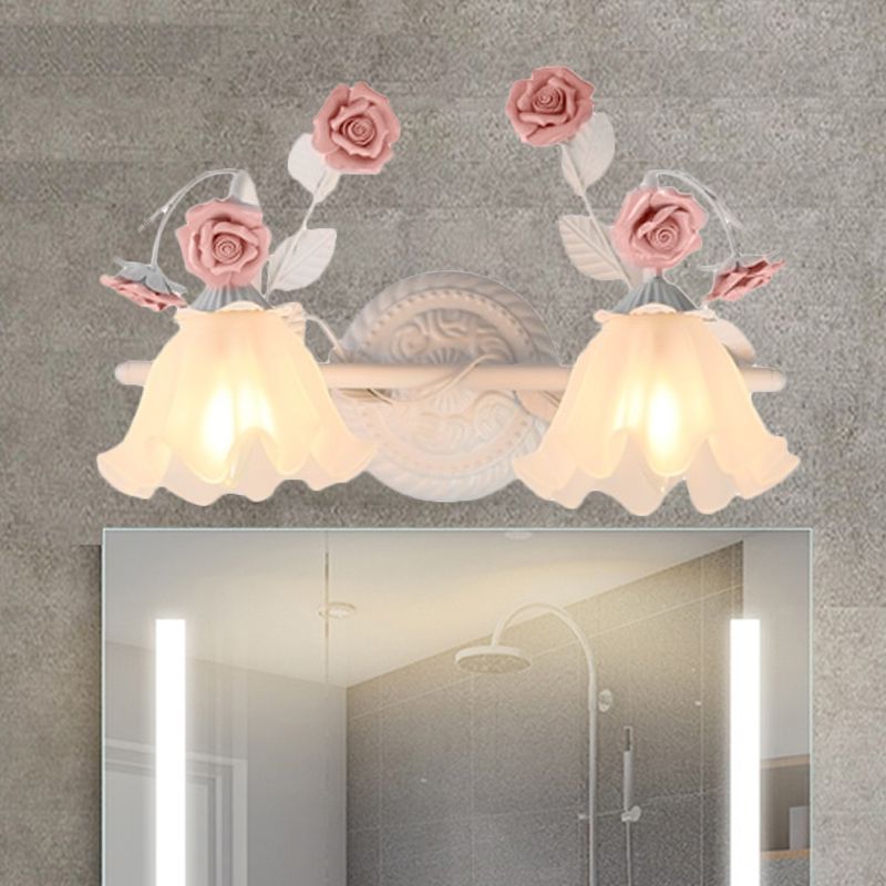 Félicie two-light pink rose fixture above a bathroom mirror