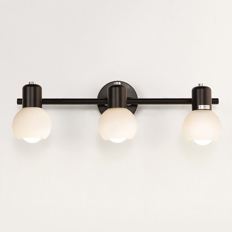 Front view of black Valentina three-head bar with centred round plate and pale glass globes