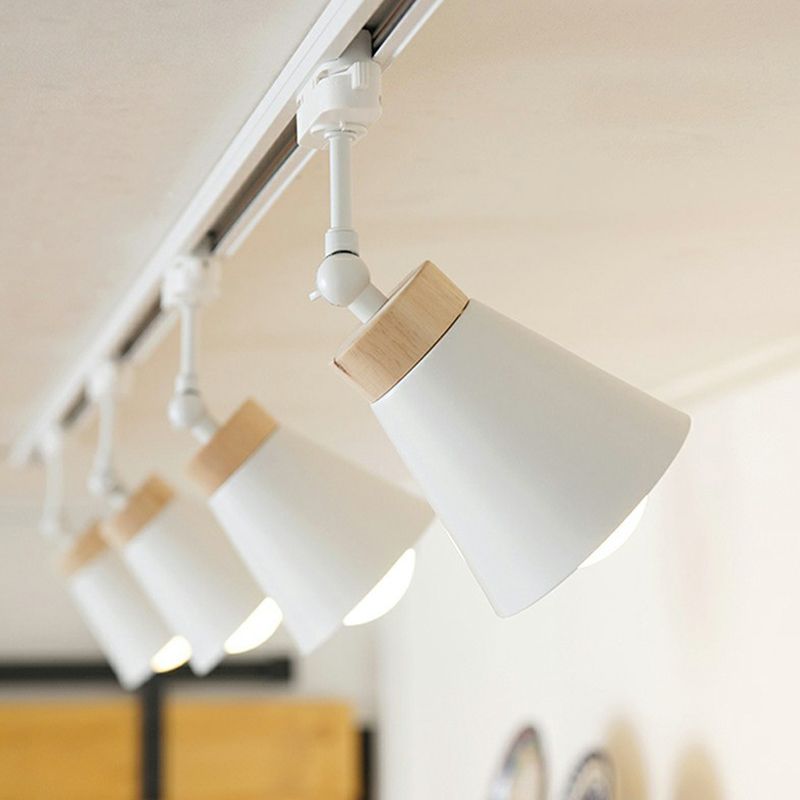 White Haney cone spotlights angled along a ceiling rail, light wood-tone collars and lit bulbs, with yellow door in background