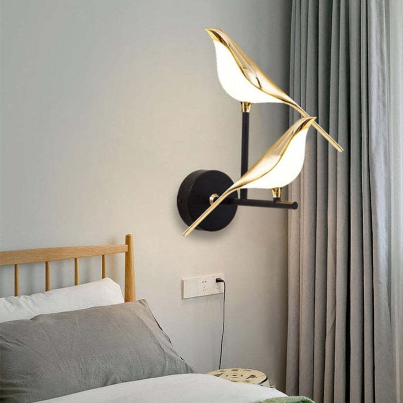 Two-bird wall lamp beside a bed and curtain
