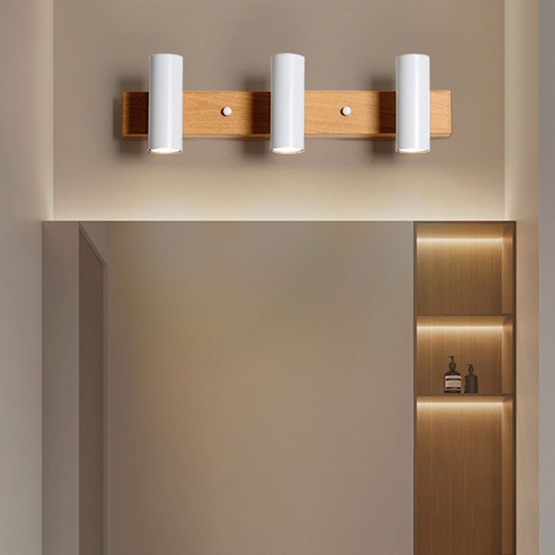 Three white cylinder heads above a wide rectangular mirror and illuminated cabinet niche