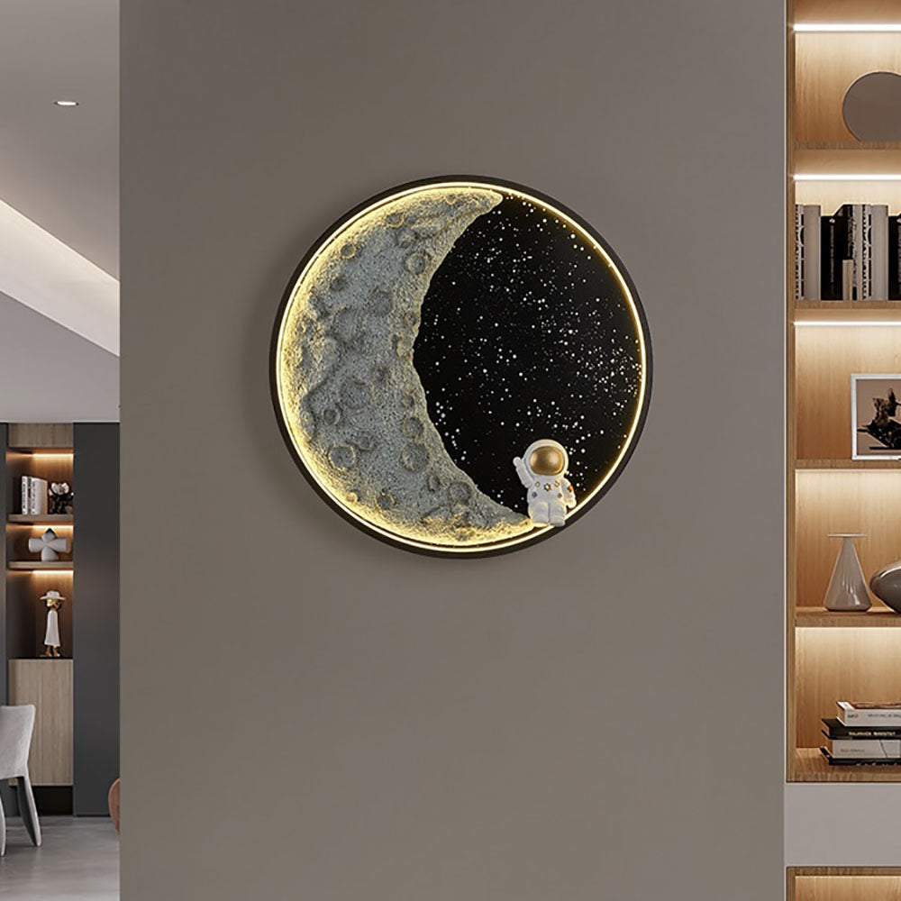 Glowing Elif crescent and astronaut wall light on a gray wall beside illuminated shelves