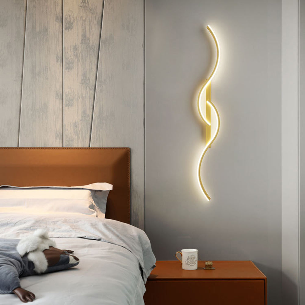 Gold Louise wall light above a brown nightstand beside a matching leather headboard