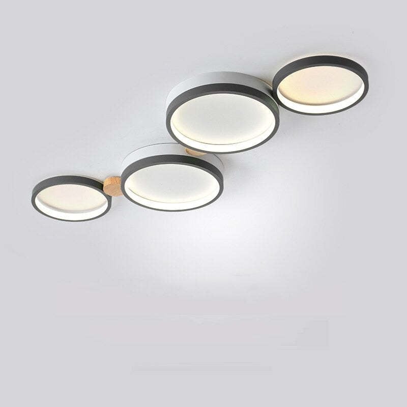 Gray four-head ceiling light with round acrylic faces, dark rims and wood connectors