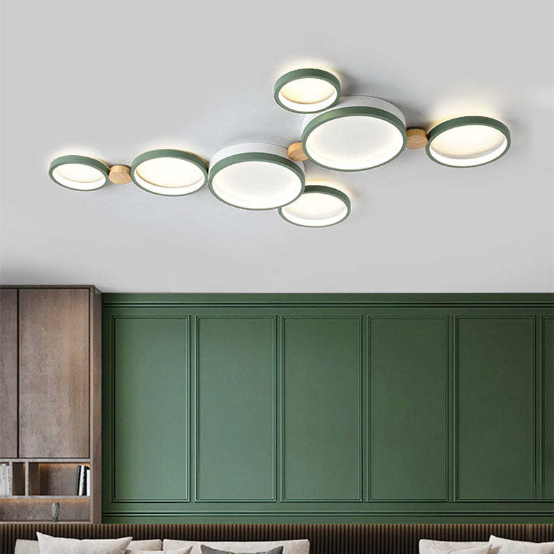 Green seven-head ceiling light above a bedroom with green paneling and wood cabinetry