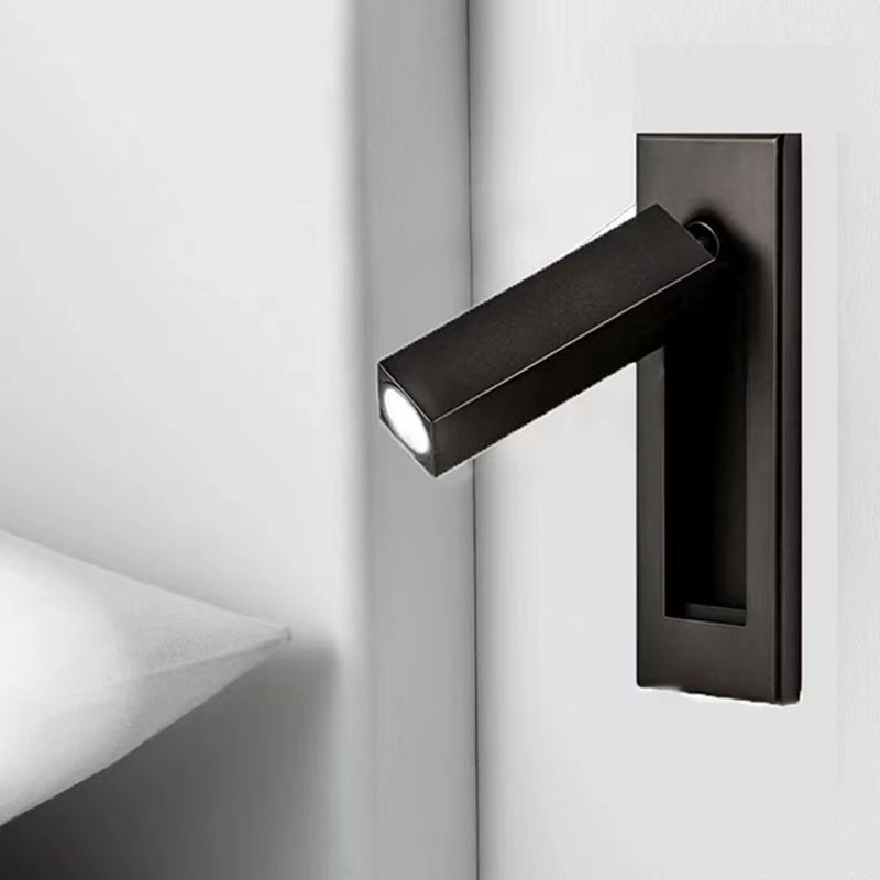Black Orr rectangular spotlight head on a wall plate beside a pale shelf