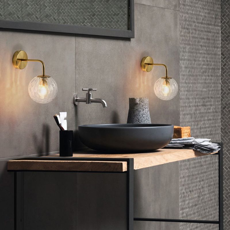 Two separate Gold Valentina glass globe wall lights beside a bathroom sink and tap