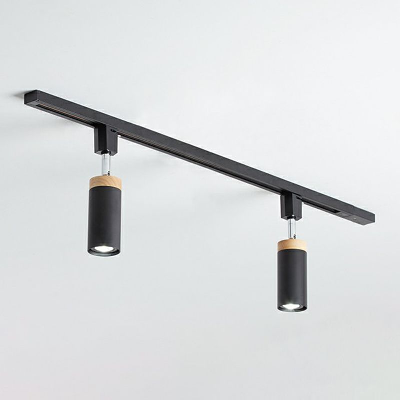 Black two-head ceiling rail fixture with downward tubular spotlights spaced along the bar