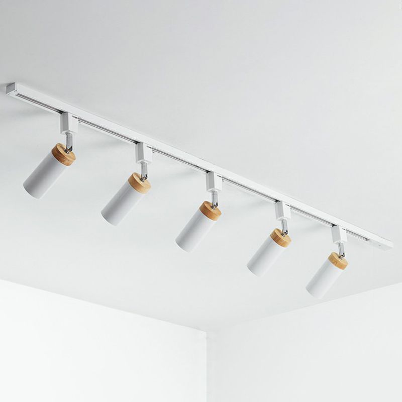 White five-head ceiling rail light with angled cylindrical spots, tan collars and short joints