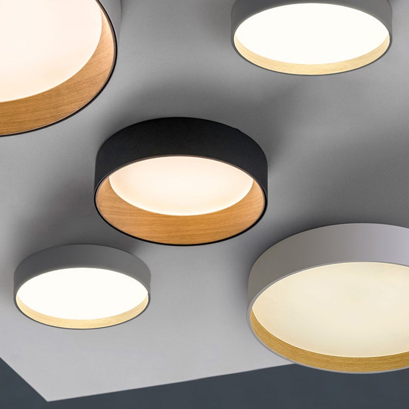Collage of several black and gray Quinn round ceiling drums with glowing inset panels and light wood-tone inner rims