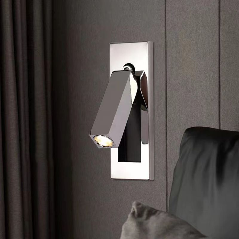 Nickel-finish Orr rectangular spotlight on a reflective wall plate beside bedding