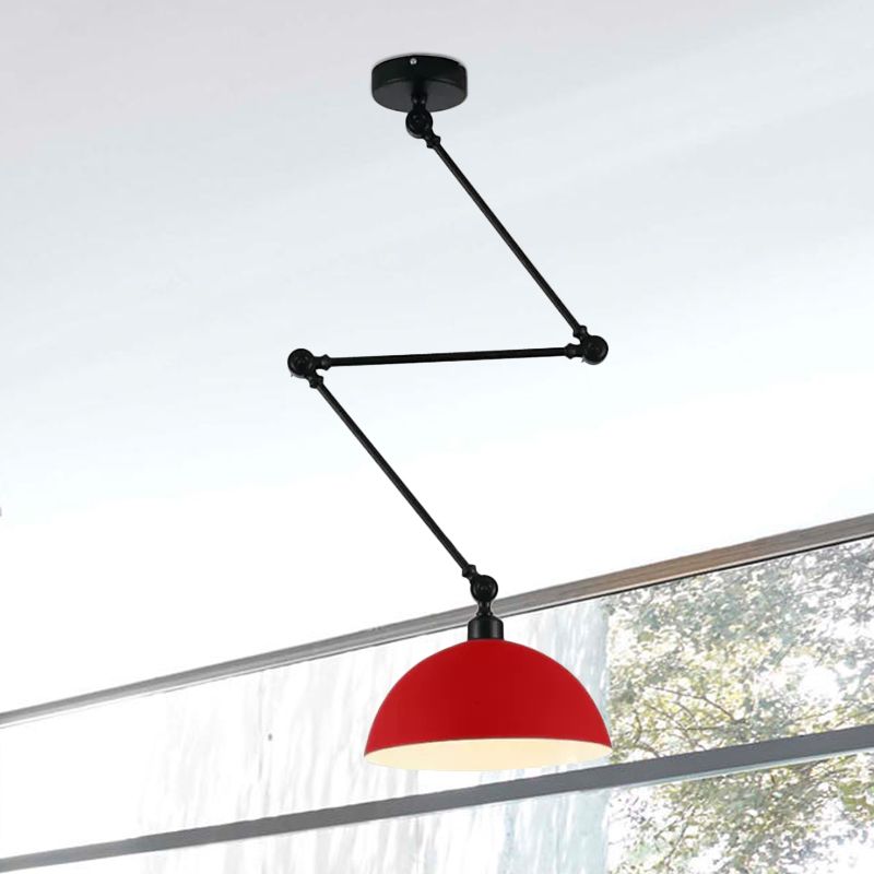 Red dome pendant with a black articulated ceiling arm beside a large sloping-top window
