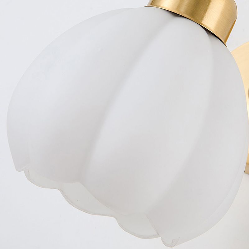Close-up of a lobed white glass shade and its scalloped petal-like rim