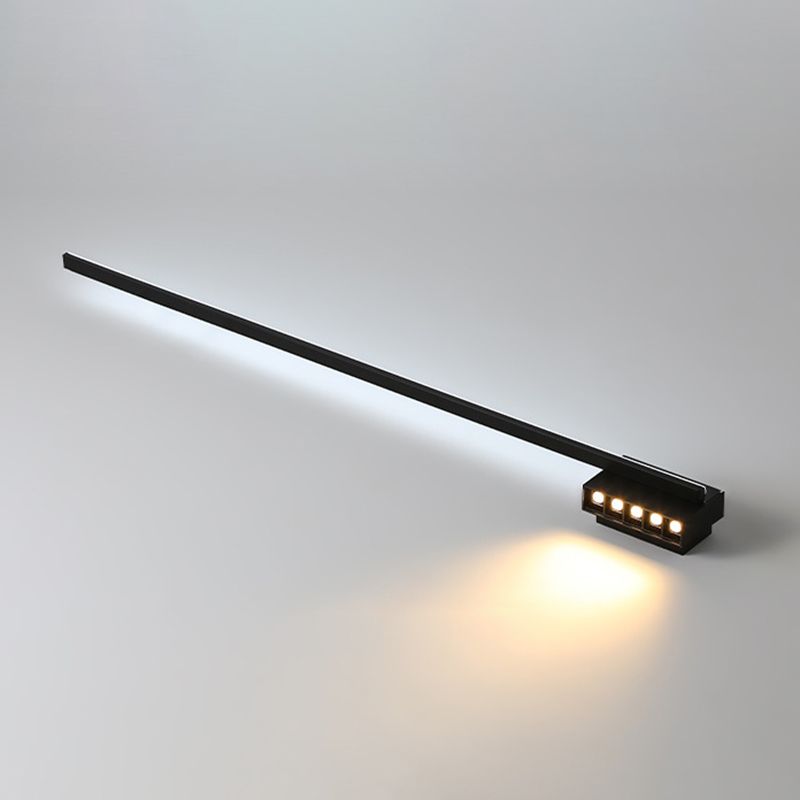 Reverse oblique view of a black wall light with a white bar strip and five warm-looking spot emitters