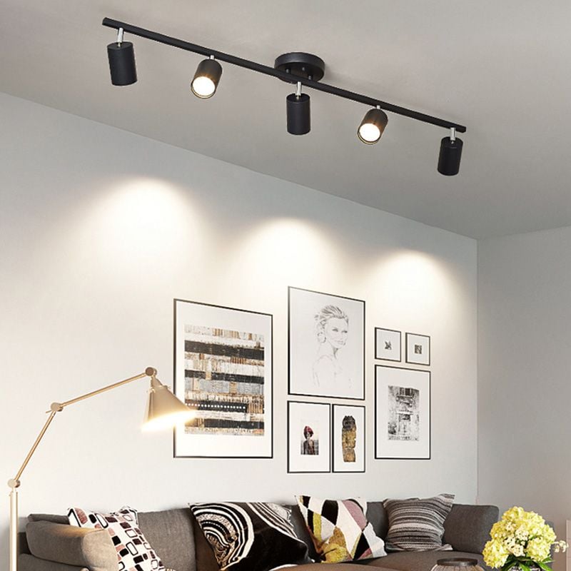 Black Freja spotlight bar with angled heads above a dark sofa