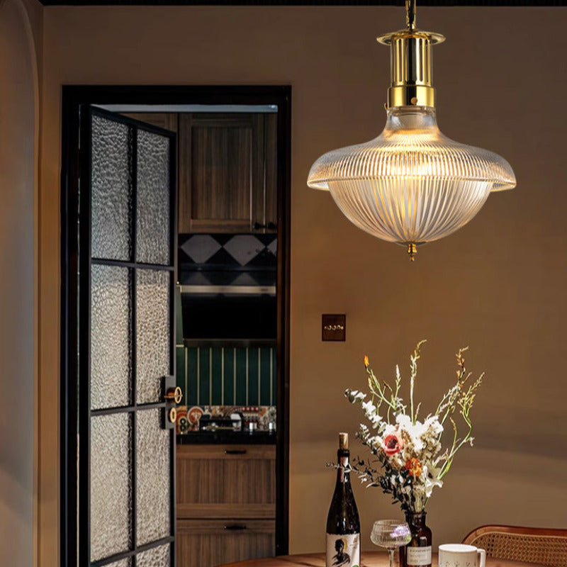 Alessio pendant beside a dark doorway above a table with flowers.