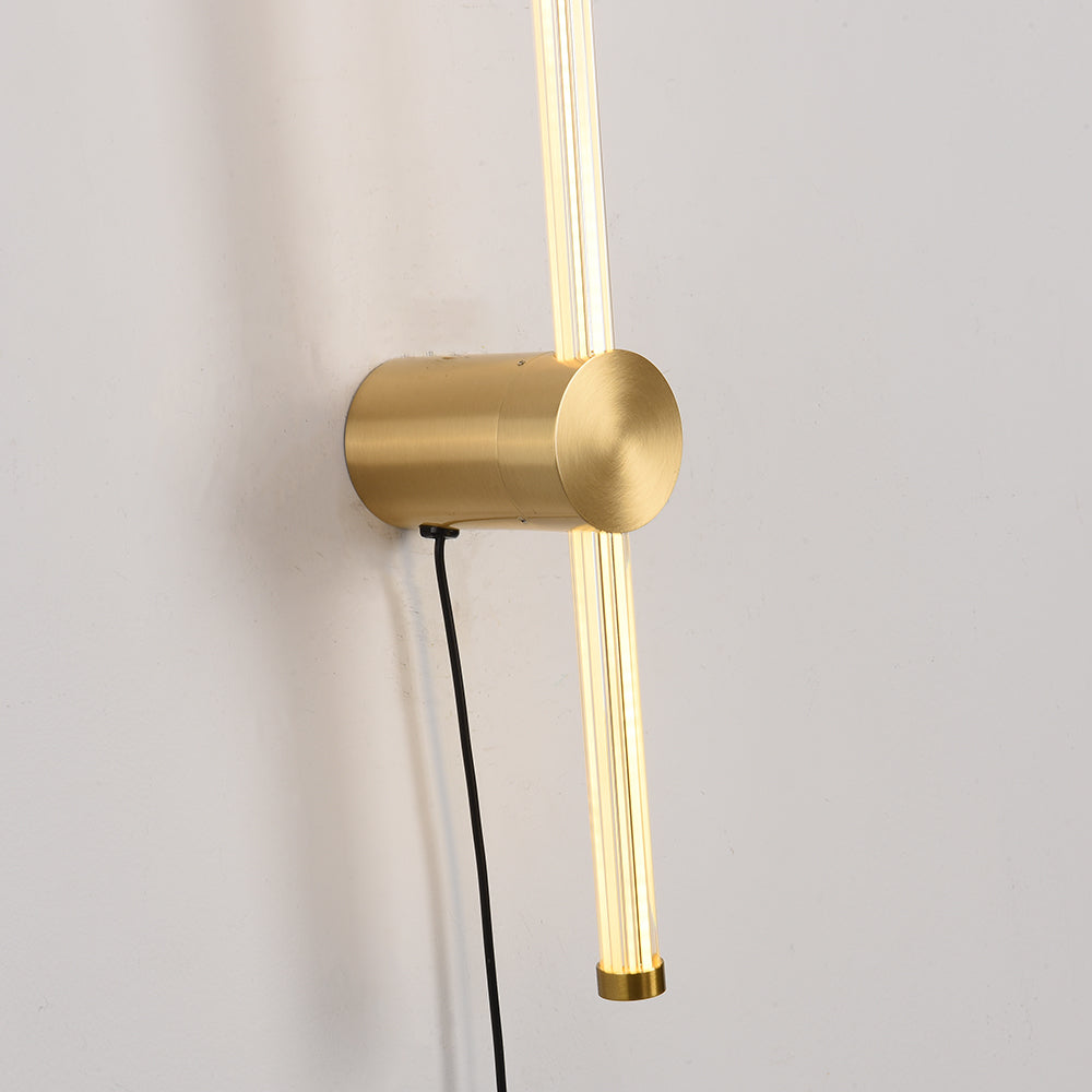 Detail of Edge gold-tone cylindrical base, glowing clear rod and black cord beneath