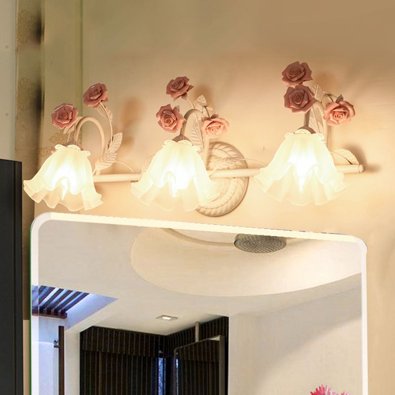 Félicie three-light pink rose fixture with downward shades above a mirror