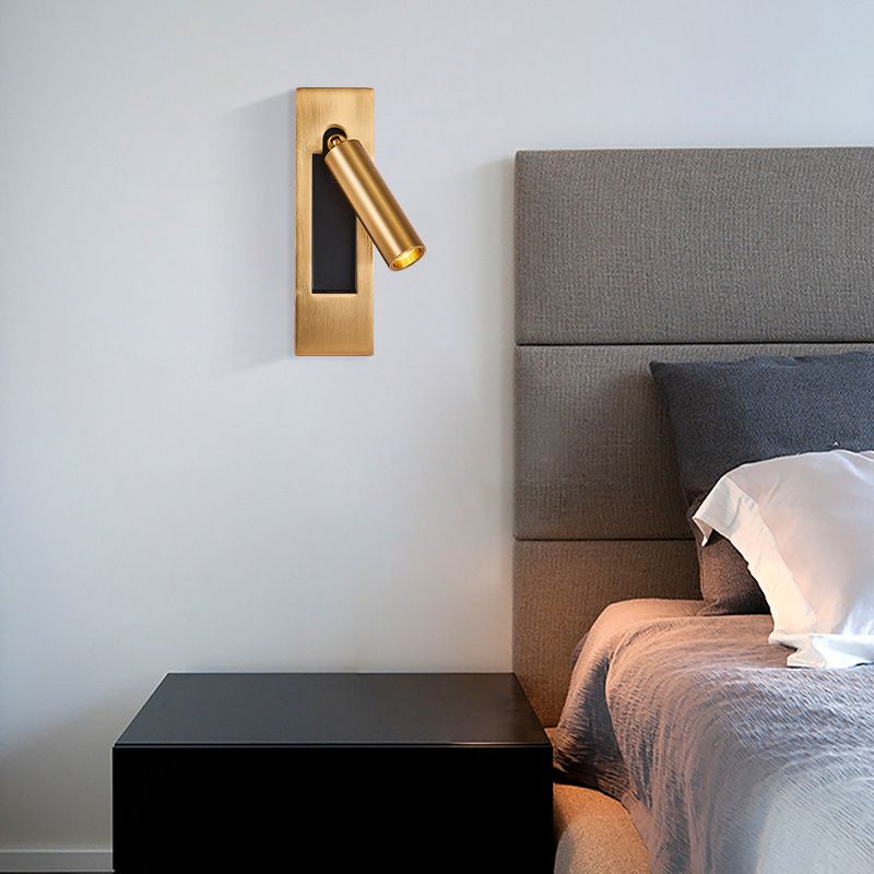 Orr gold-colour wall spotlight beside an upholstered headboard