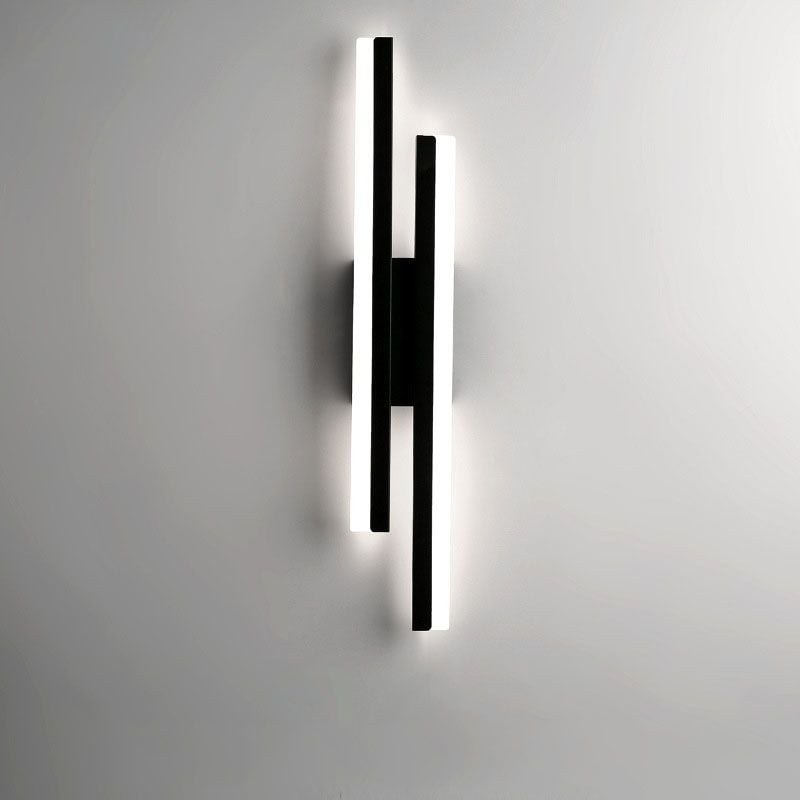 Black offset-bar wall light with the left bar starting higher and pale light faces