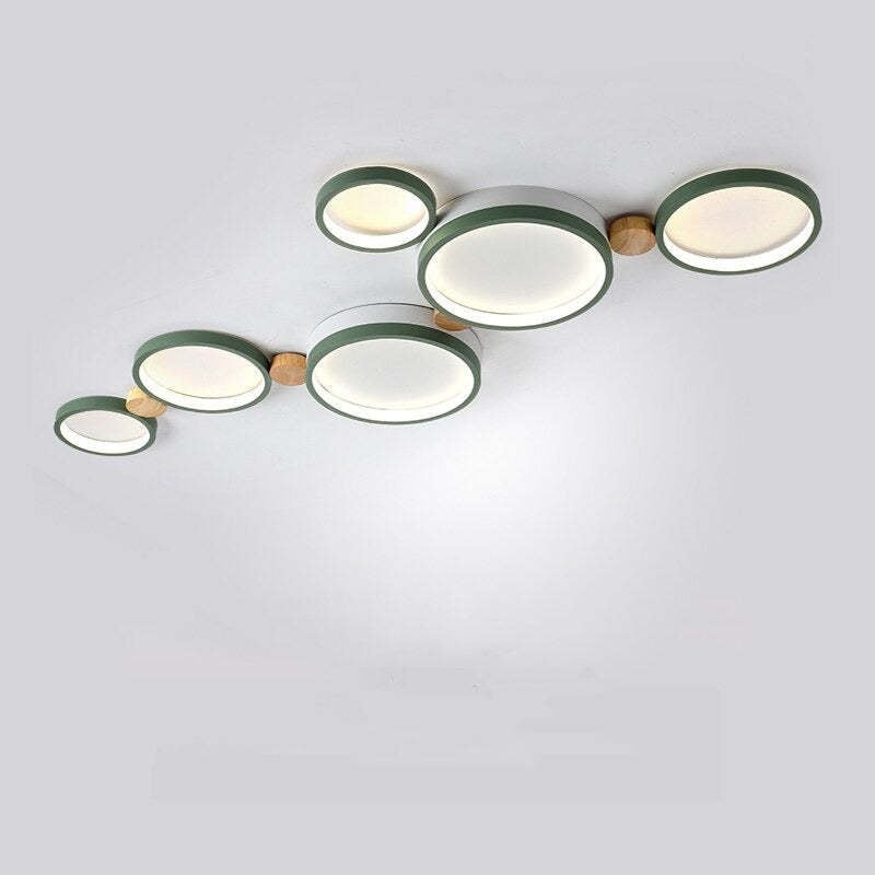 Green six-head disc ceiling light with white light faces and wood details against a pale ceiling