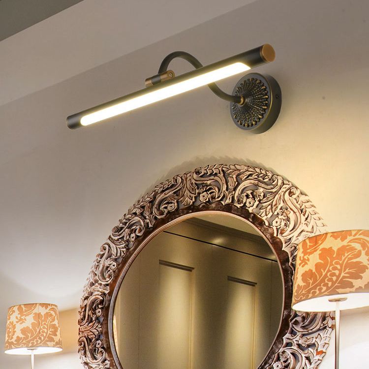 Black linear bar light above an ornate arched mirror