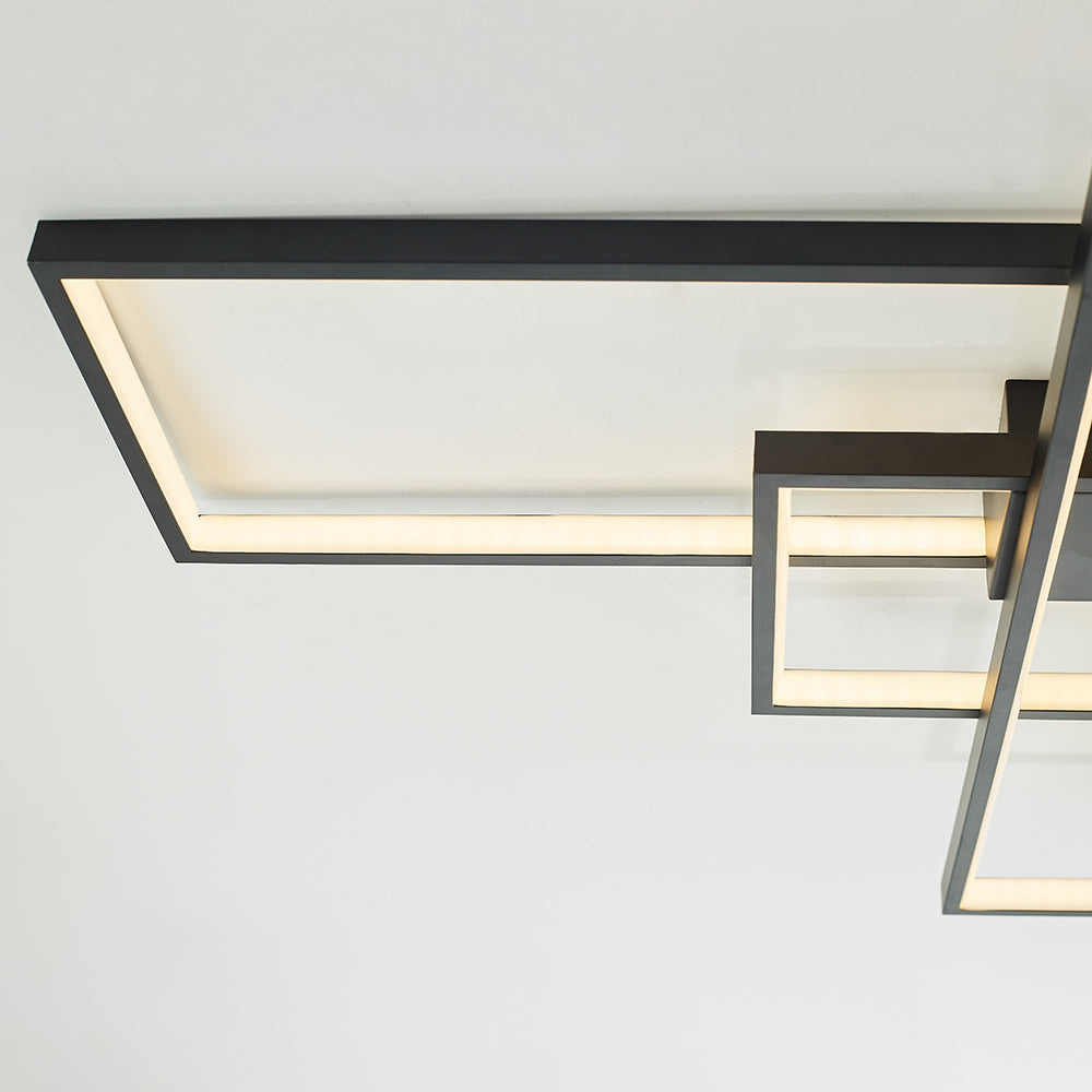 Close-up of a black long rectangular frame crossing a smaller frame, with warm-looking diffuser strips