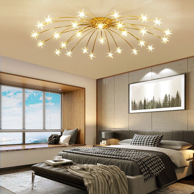 Gold-tone glass star ceiling light above bed with checked bedding, window seat and framed forest print