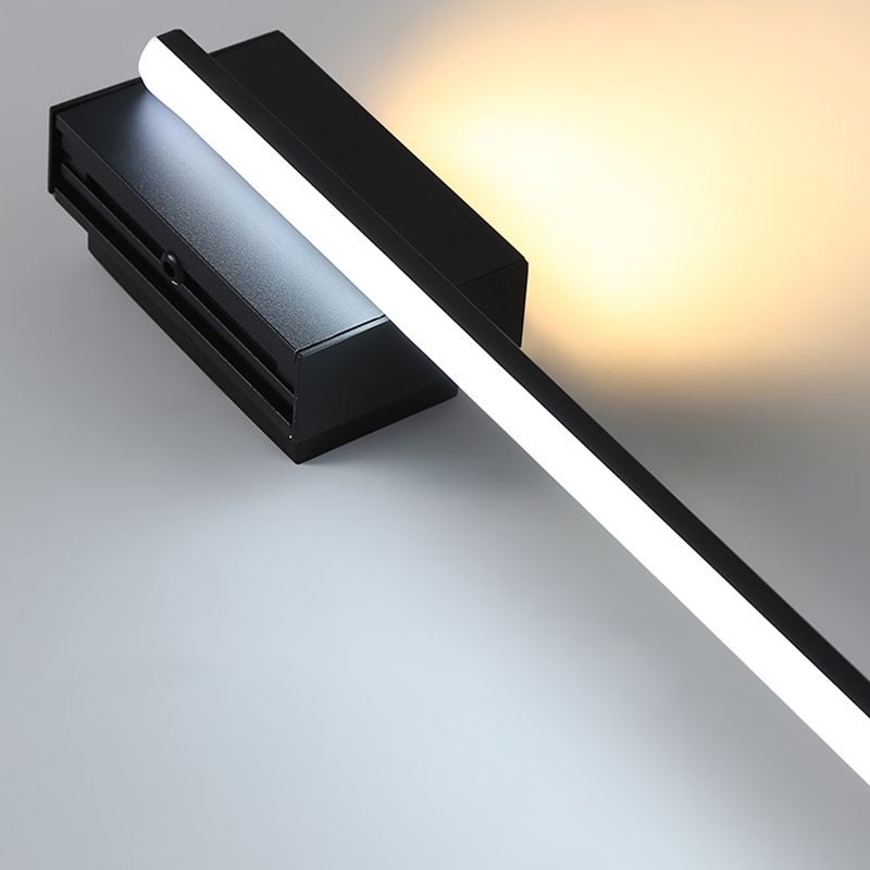 Angled detail of the black end plate and bright lower diffuser strip, with warm light beyond the plate