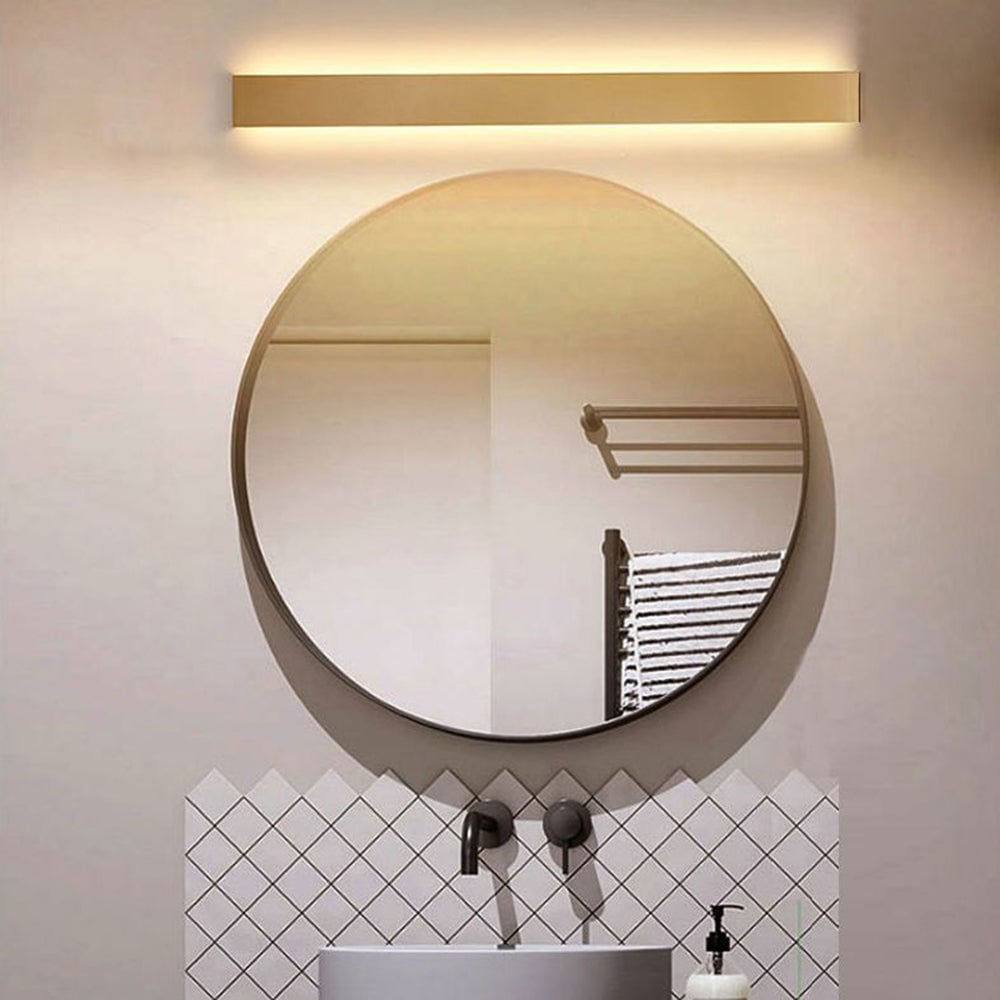 Gold Edge wall light installed horizontally above a round bathroom mirror.