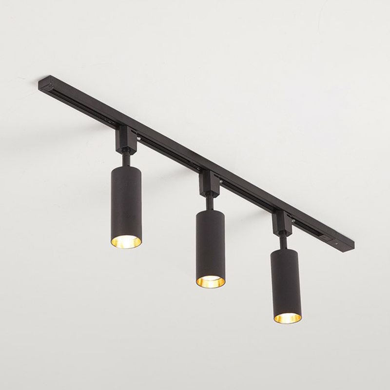 Large black three-head ceiling spotlight with longer cylinders on a black rail