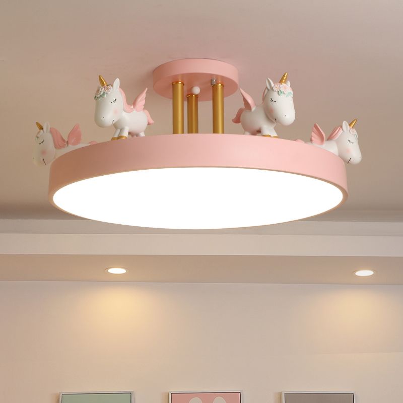 Pink unicorn semi-flush ceiling light with gold-tone posts above framed room pictures