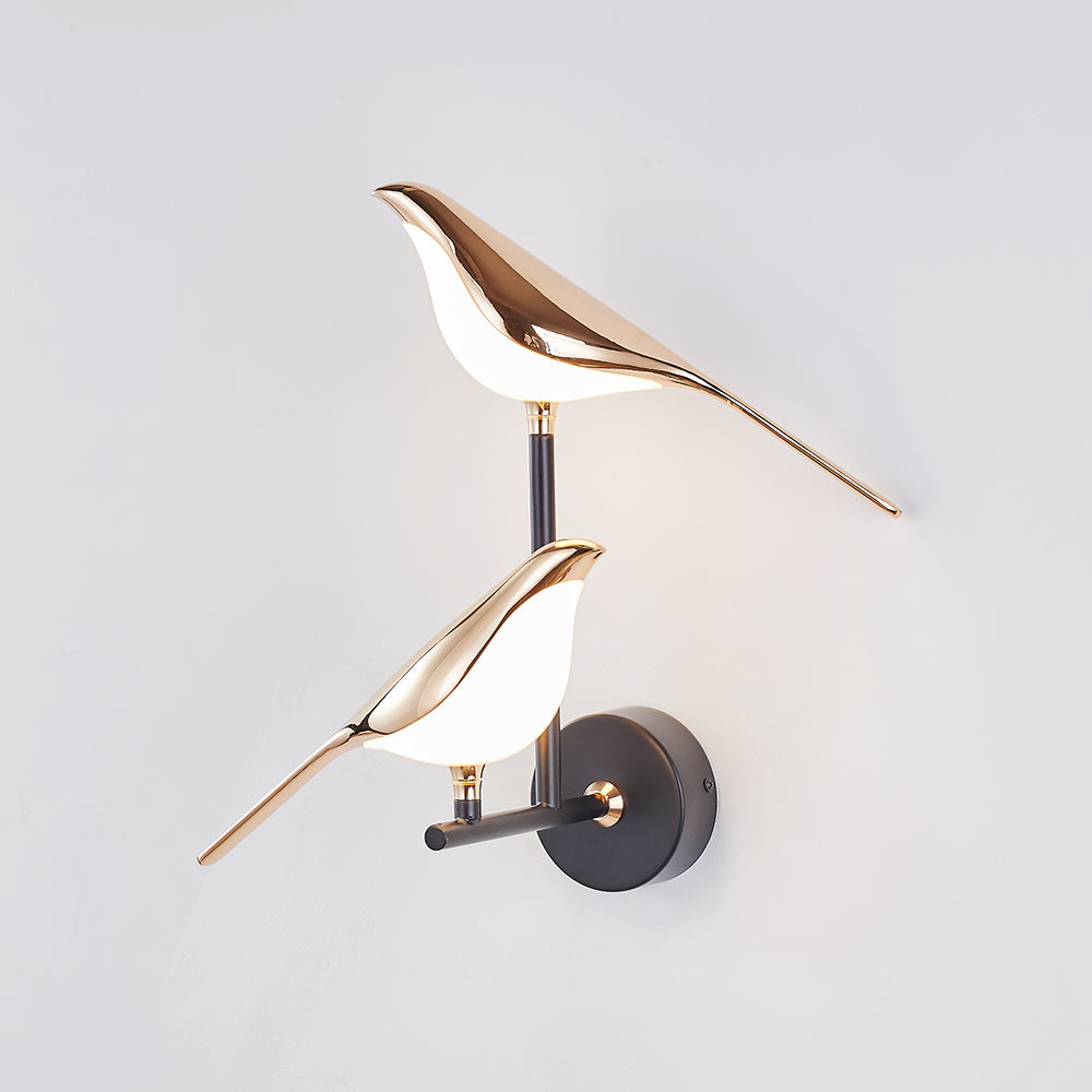 Two Gold bird forms against a light background
