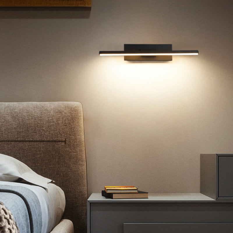 Horizontal black bar wall light beside a bedside cabinet