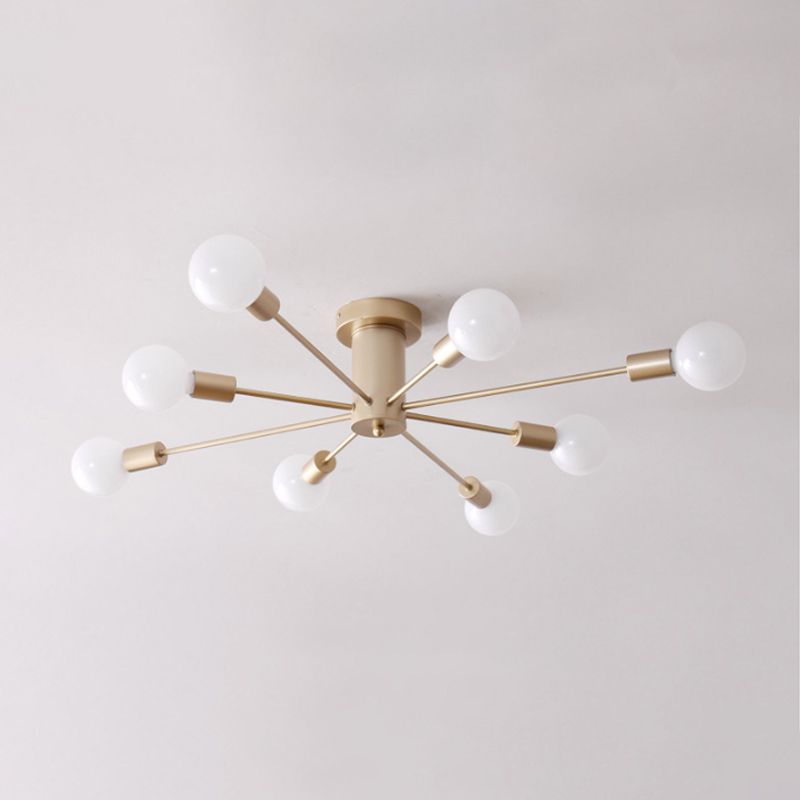 Close view of unlit gold eight-light fixture with exposed white bulbs and cylindrical centre