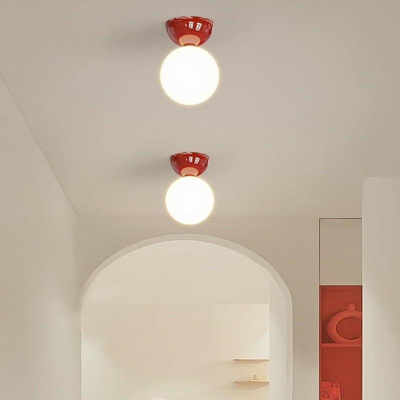 Red Valentina globe ceiling lights beside an arched hallway opening