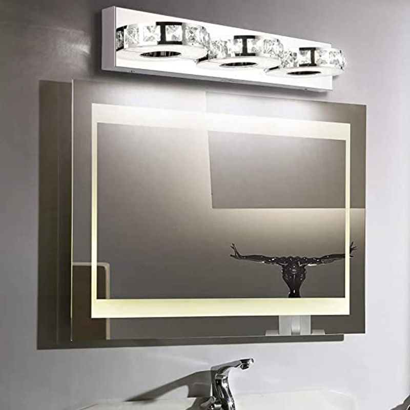 Kristy three-head wall lamp above a framed mirror