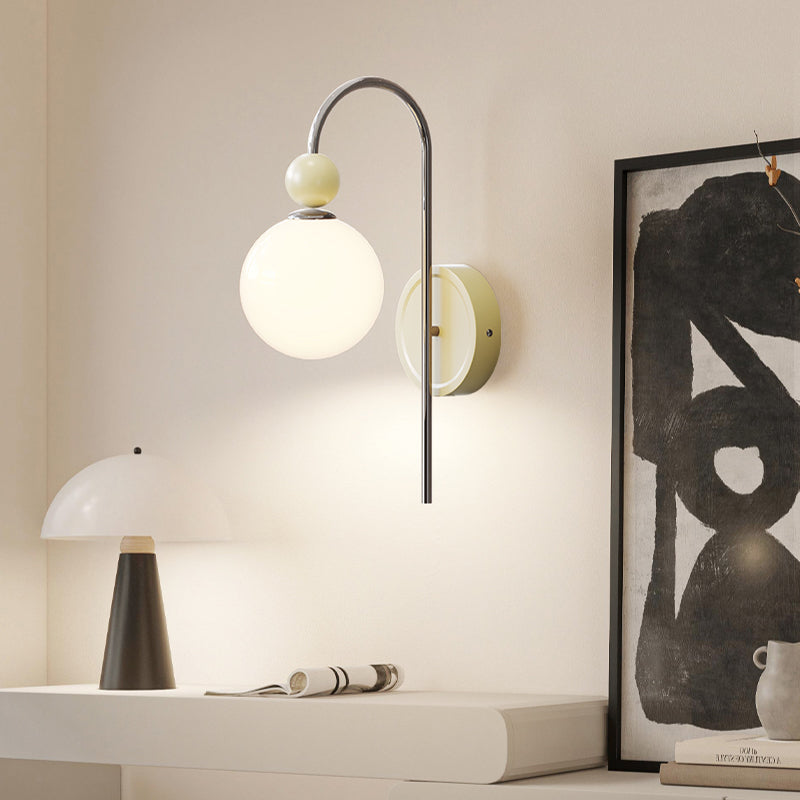 Pale Model B globe light above a desk beside framed art