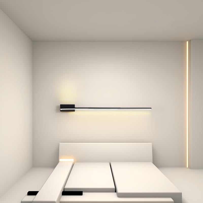 Black linear wall light above a white sectional sofa with warm-looking light and separate room lighting