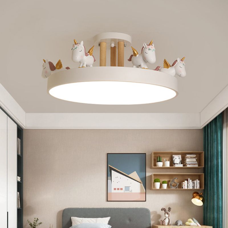 White unicorn ceiling light above a grey upholstered bed, framed artwork and wall shelves